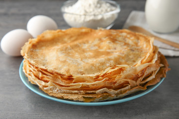 Canvas Print - Plate with stack of delicious thin pancakes on table