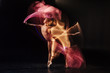 © zinkevych - Professional dance studio. Attractive nice skillful woman standing against black background and dancing while being in the professional dance studio