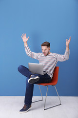 Sticker - Young man with laptop against blue wall