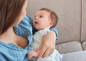 Sticker - Young mother holding baby at home