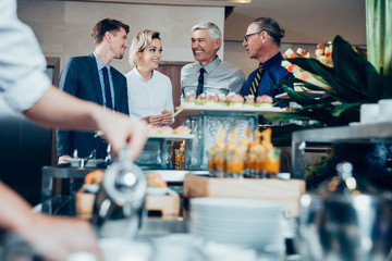 Four Smiling Business People at Buffet Table