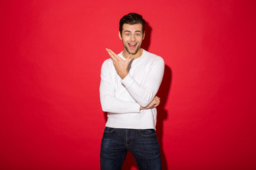 Wall Mural - Image of Surprised happy man in sweater looking at camera