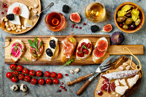 Fotografía Appetizers table with italian antipasti snacks and wine in glasses