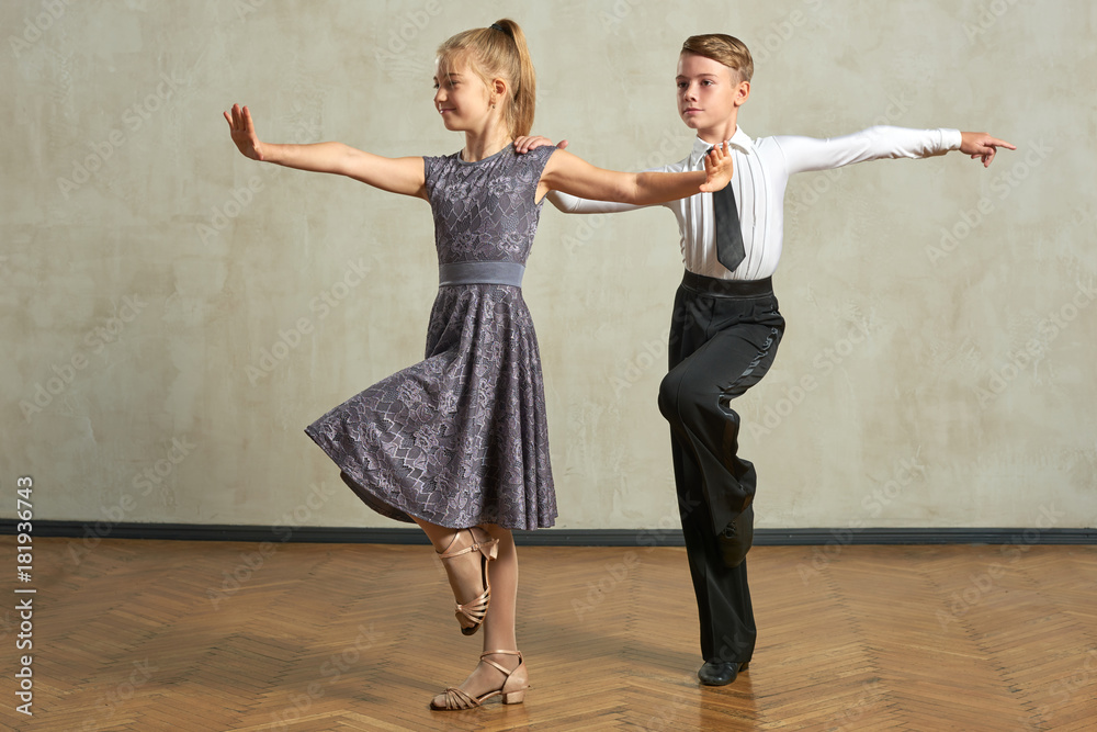 Attractive young couple of children dancing ballroom dance in studio - obrazy, fototapety, plakaty 