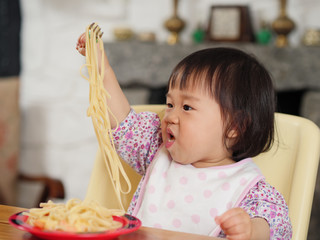 Wall Mural - baby girl eating at home