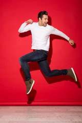 Wall Mural - Full length image of happy man jumping and looking back