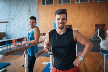 two smiling guys in oldschool wooden gym;