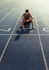 Wall Mural - sprinter relaxing on running track