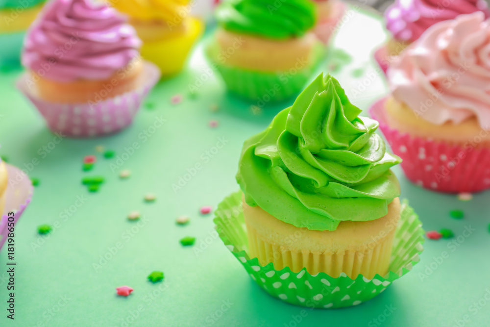 Tasty cupcakes on color background