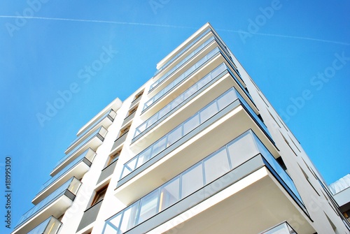 Plakat Nowożytni budynki mieszkaniowi na słonecznym dniu z niebieskim niebem. Fasada nowoczesnego budynku mieszkalnego