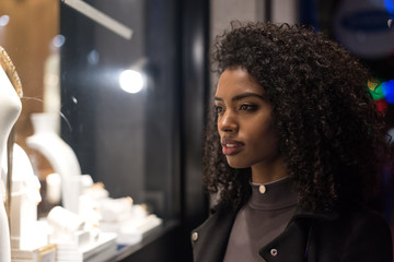 Black young woman watching a display in a showcase