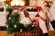 Woman hand arranging Christmas goods in a basket. Festive holiday food gift concept