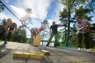 Males And Females Picking Up Wooden Blocks With Ropes