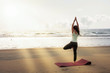 Junge Frau meditiert beim Yoga am Strand