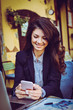 © liderina - Business woman sitting at cafe using smart phone.