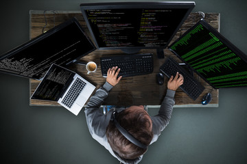 Fototapete - Hacker Hacking Multiple Computers On Desk