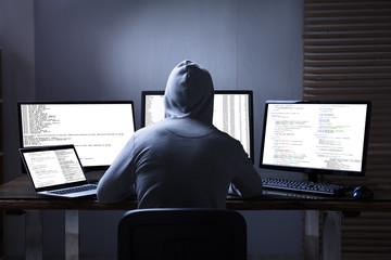 Wall Mural - Hacker Using Multiple Computers For Stealing Data