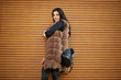 © AS Photo Family - Fashion outdoor photo of gorgeous sensual woman with dark hair in elegant clothes and luxurious fur coat and with backpack against shutter background.