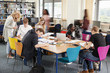 © Monkey Business - Busy College Library With Teacher Helping Students At Table