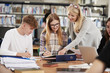 © Monkey Business - Female Teacher Working With College Students In Library