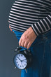 © Bits and Splits - Pregnant female with vintage alarm clock