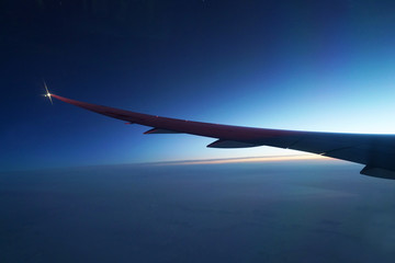 Wall Mural - airplane wing and twilight sky before sunrise