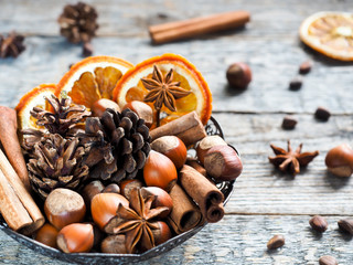 Wall Mural - Winter ingredients nuts, cones, oranges, cinnamon star anise in a bowl. Rustic style