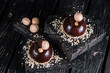 Two french chocolate mousse cake on wood background. Dessert decorated with macaroon, nut and piece of chocolate bar 