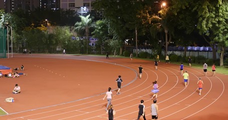 Wall Mural - Tin Shui Wai, Hong Kong, 26 October 2017:- People running in sport stadium at night