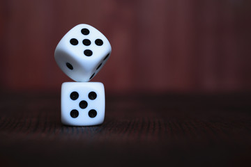 Wall Mural - Pile of two white plastic dices on brown wooden board background. Six sides cube with black dots. Numbers 1, 3, 5.