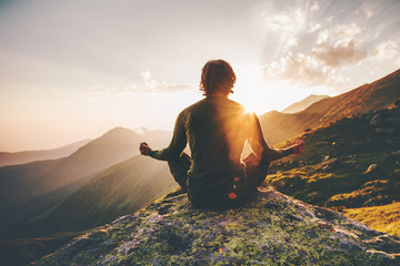 Wall Mural - Man meditating yoga at sunset mountains Travel Lifestyle relaxation emotional concept adventure summer vacations outdoor harmony with nature