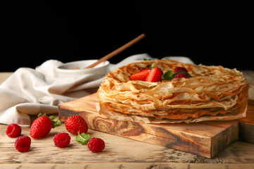 Sticker - Delicious thin pancakes with berries on wooden board