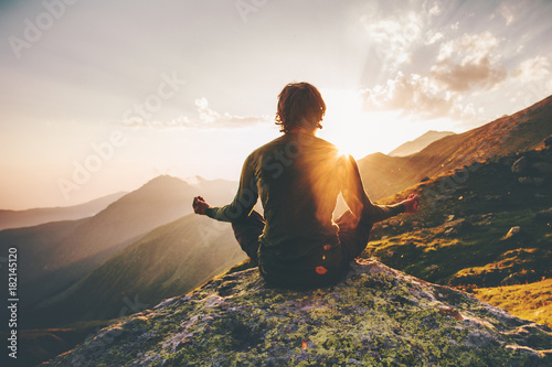 Fotografie, Obraz Man meditating yoga at sunset mountains Travel Lifestyle relaxation emotional co