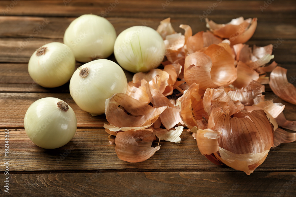 Raw peeled onion on wooden background