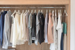 wooden closet with clothes hanging