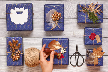 Sticker - Woman wrapping christmas presents over wooden background