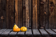 Three Fall Gourds On A Rustic Wooden Table.