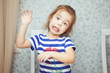 © Ilshat - Cute little girl in striped T-shirt makes funny face