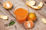 Fototapeta Kuchnia - Citrus juice in glass and fresh mandarin orange on wooden background