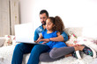 © Spectral-Design - Black father and his daughter siting on a couch with a laptop