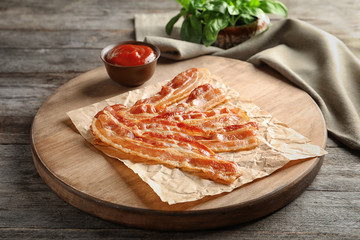 Wall Mural - Board with cooked bacon rashers on wooden table