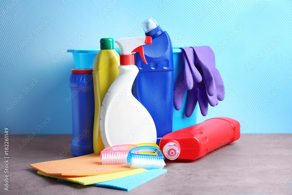 Cleaning supplies on color background