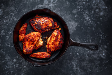 Wall Mural - Cooked chicken fillets, breast supremes in rustic cast iron skillet.