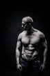 © markhipov - portrait of a male bodybuilder, straining muscles in sports poses, on a black background is isolated. monochrome. The concept of a photo of competing sports, health, fitness