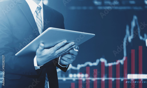 Fotografía Businessman using digital tablet, raising graph background