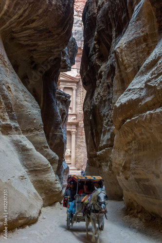 Fotografie, Obraz Horse buggy leave the Treasury through the Siq in Petra, Jordan