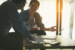 © boonchok - Happy business people looking at report and having a discussion in office.