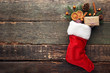 Christmas stocking with fir-tree branch, dried oranges and cinnamon on wooden table