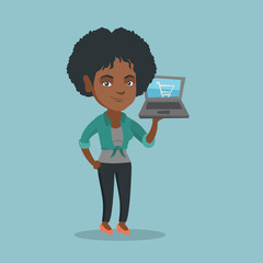 Sticker - Young african-american woman holding a laptop with a shopping cart on a screen. Woman using a laptop for online shopping. Woman doing online shopping. Vector cartoon illustration. Square layout.