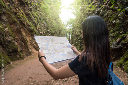Cuadros en Lienzo Back side of young traveler see the map in the deep forest, Hellfire Pass at kan